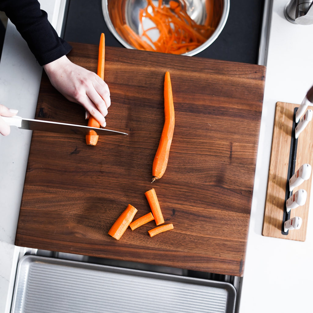 chopping carrots on wood cutting board