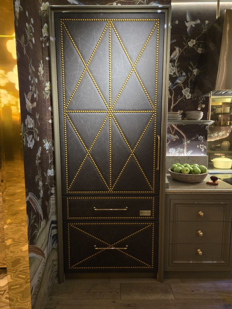 20260219_081719 A full-size refrigerator/freezer clad in leather, complete with decorative nail head trim.