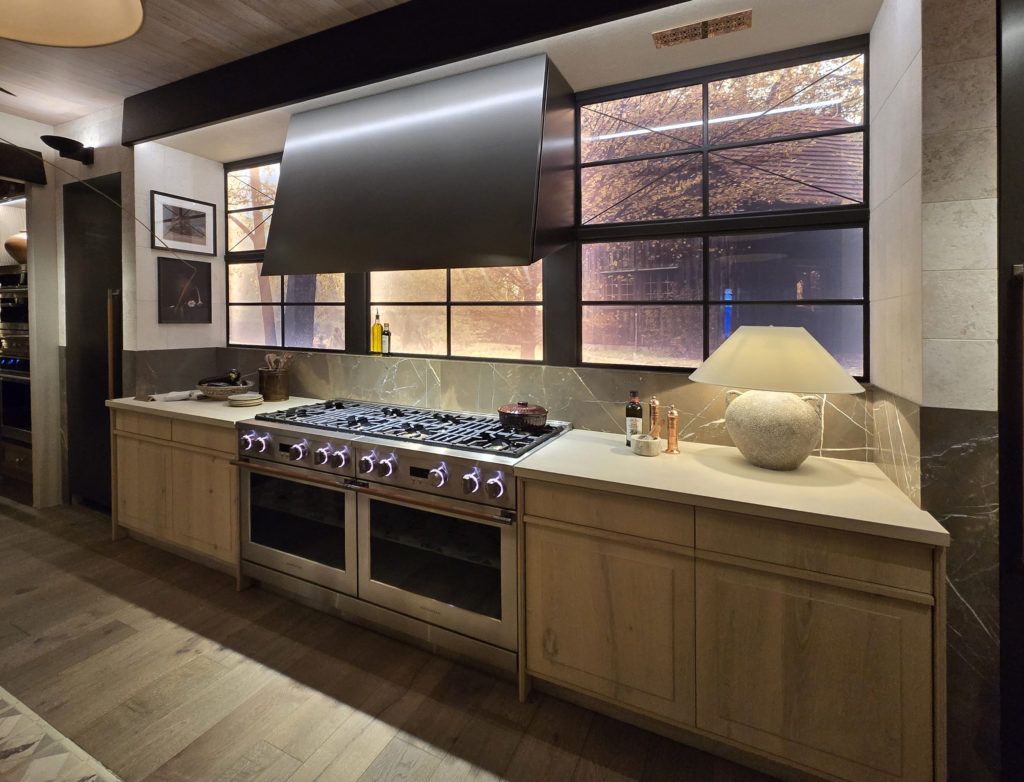 Bentwood-KBIS2026-Cooking-Elevation-1-No-Mark Monogram range and titanium hood at KBIS 2026 booth with Bentwood cabinetry